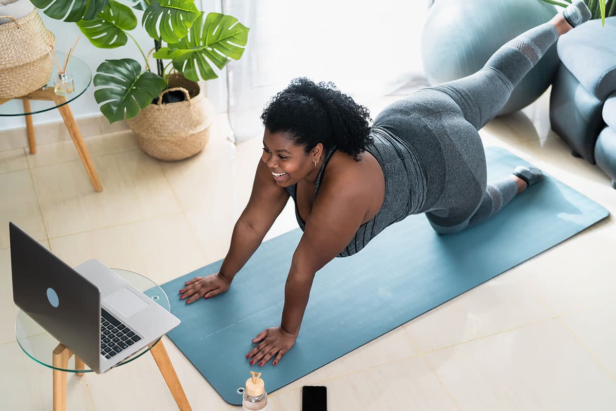 woman looking at a laptop and doing yoga in her home after Laparoscopic surgery in Marion and Mount Vernon