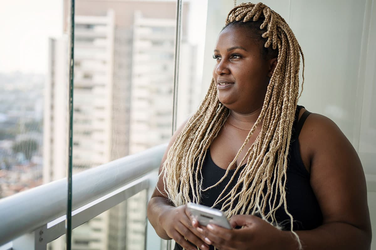woman looking out a window of a skyscraper in a city before medical weight loss in Marion and Mount Vernon