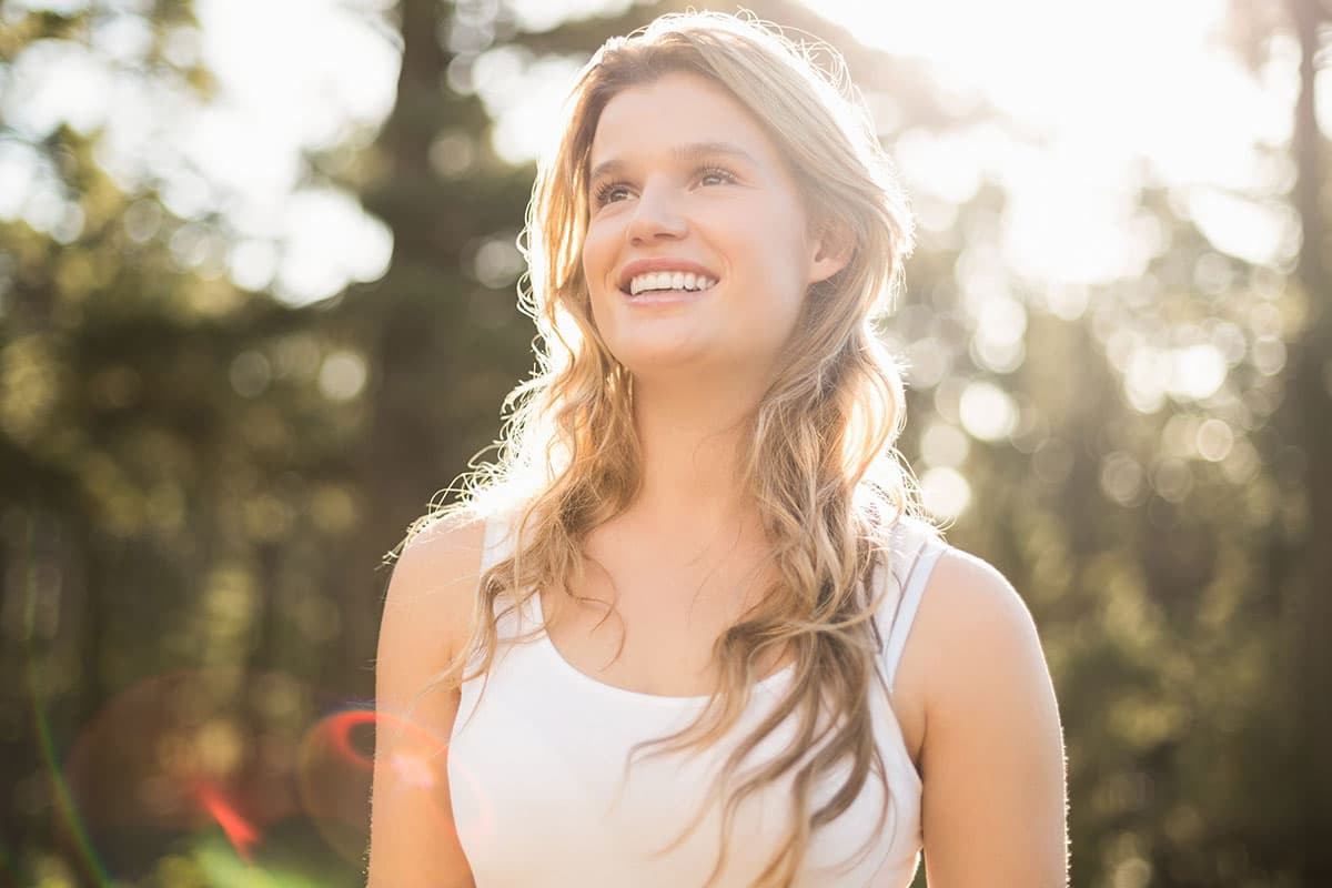 woman smiling outside in the sunshine after Tummy Tuck in Marion & Mount Vernon